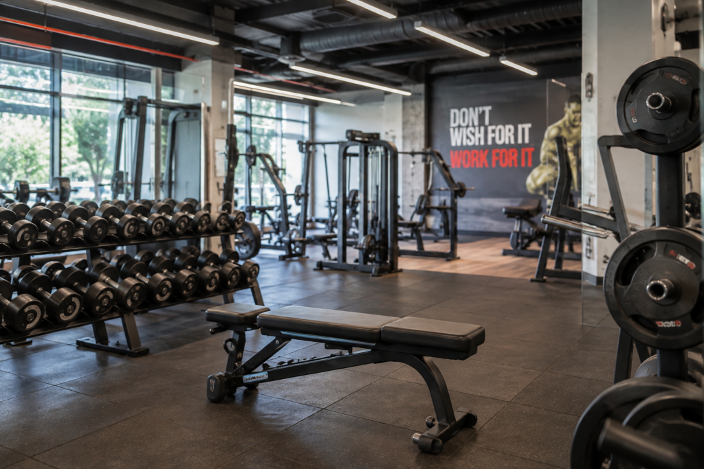 Fully equipped gym with dumbbell racks, weight machines, and benches